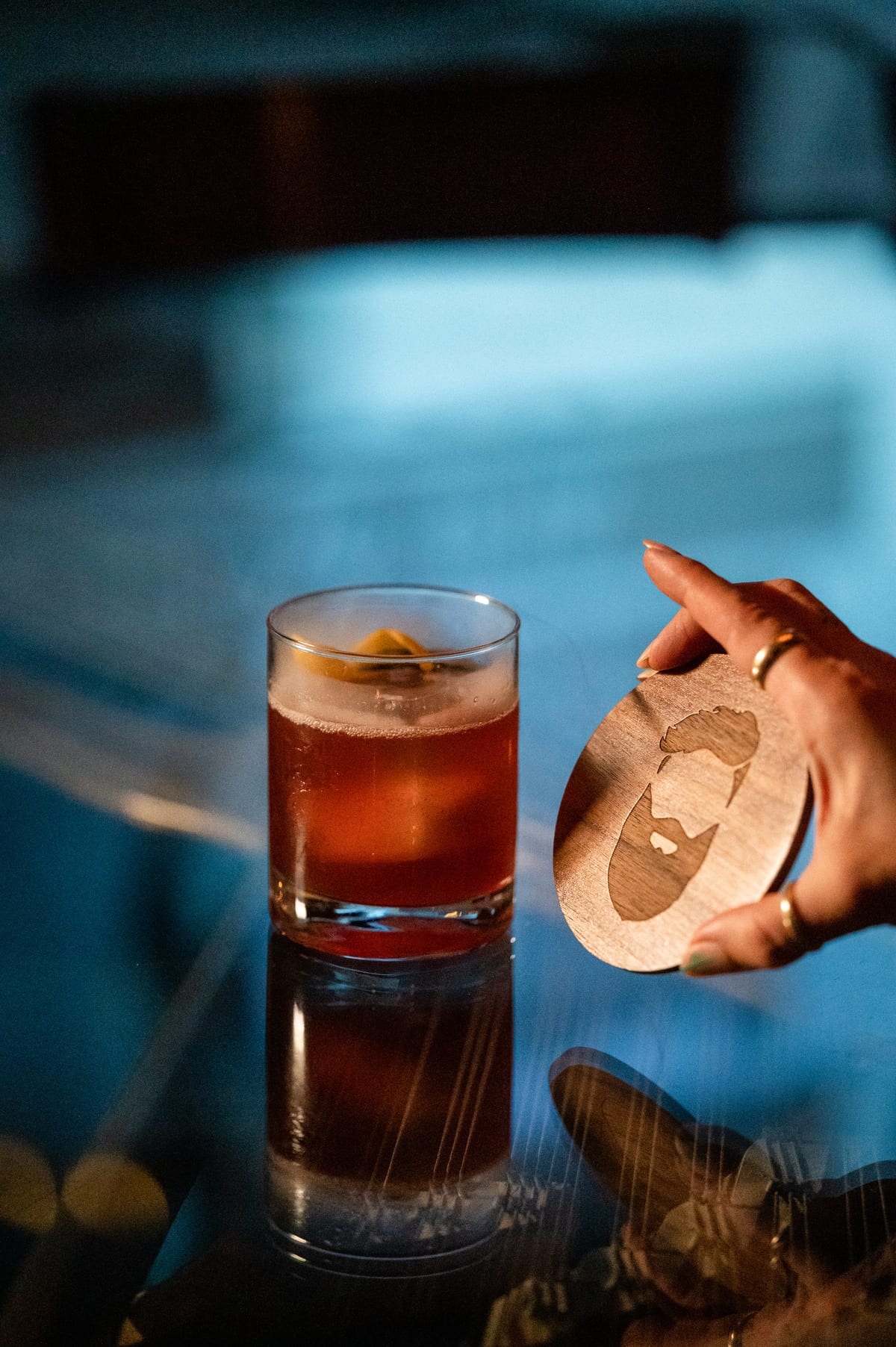 Craft cocktail with the Bookcase barber-bearded logo coaster — where the barbershop meets the speakeasy