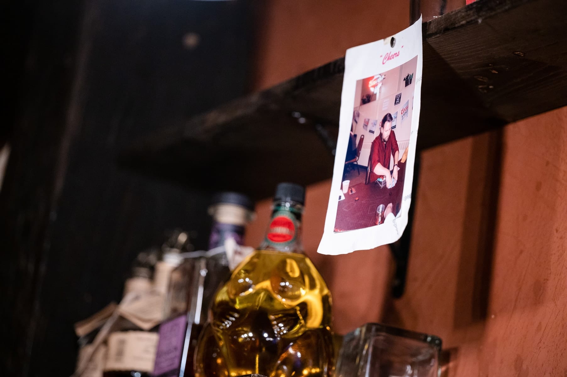 Whiskey bottles and a vintage Polaroid on the speakeasy shelf — the Bookcase story told in spirits